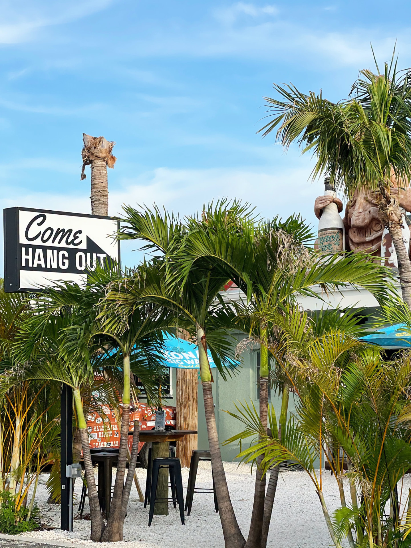 Come Hang Out sign and palm patio at Saltwater Hippie
